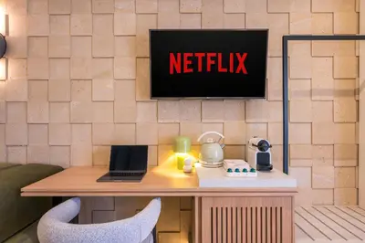a netflix sign on a wall with a desk with a laptop at Agave Suites in Chania Town