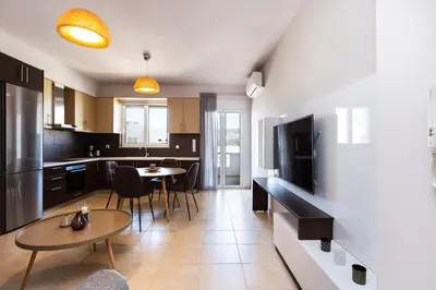a kitchen with a table and a dining room at Ethereal Apartments Chania in Souda
