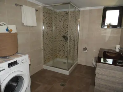 a bathroom with a shower and a washing machine at Chrissi's house with garden and sea view Zerviana in Kissamos