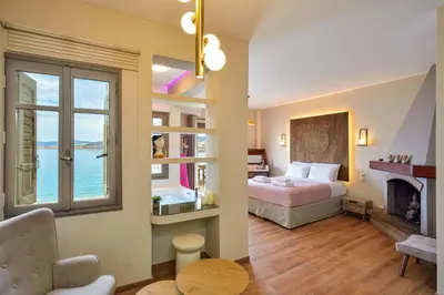 a hotel room with a bed and a fireplace at East Seafront Suite in Chania Town