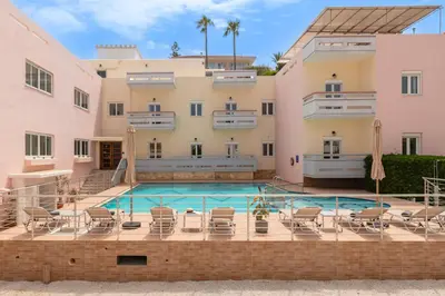 a swimming pool in front of a building at Thelèsi Apartments, 100m from the beach in Stalos