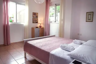 a bedroom with two beds and two windows at Villa SteMa in Xirokámbion