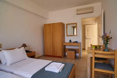 a bedroom with a bed and a table and a chair at Veronica Hotel in Kato Daratso