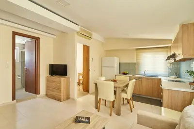 a kitchen and living room with a table and chairs at Veronica Hotel in Kato Daratso