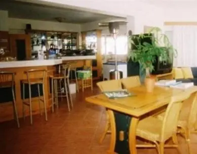 a kitchen with a table and chairs and a bar at Veronica Hotel in Kato Daratso