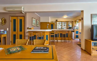a living room with a table and a kitchen at Veronica Hotel in Kato Daratso