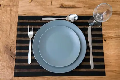 a table with a blue plate and fork and knife at Elegant Apartment in Chania Town