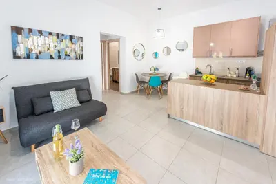 a living room with a couch and a kitchen at Orama Suites II in Kato Daratso