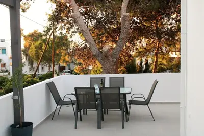 a table and chairs on a balcony with a tree at Orama Suites II in Kato Daratso