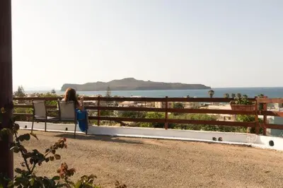 a woman sitting on a bench looking at the ocean at Stalos View in Stalos