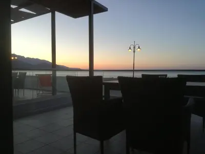 a restaurant with a view of the ocean at sunset at Casa Bella Deluxe Apartments in Palaiochóra