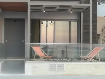 two chairs and a table on a balcony at Casa Bella Deluxe Apartments in Palaiochóra