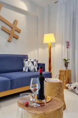 a living room with a blue couch and a bottle of wine at Ikia Aretousa in Kato Daratso