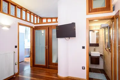 a living room with a tv on a wall at Blue Suite by Cosmos in Plataniás