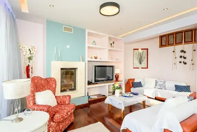 a living room with a couch and a tv at Blue Suite by Cosmos in Plataniás