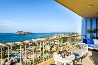 a balcony with a table and chairs and a view of the ocean at Blue Suite by Cosmos in Plataniás