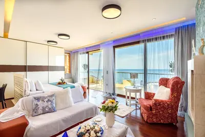 a living room with a white couch and chairs at Blue Suite by Cosmos in Plataniás