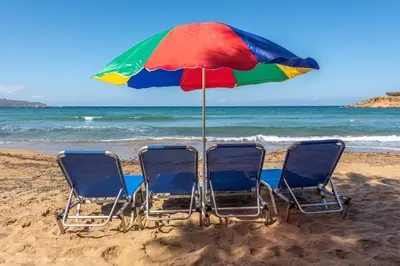 two chairs and an umbrella on the beach at Orama Suites I in Kato Daratso