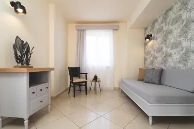 a living room with a couch and a chair at Zeus Village Resort - Adults Only in Kato Daratso