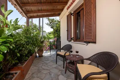 a patio with chairs and a table and a window at Elisavet's House in Plataniás
