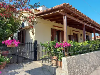 a house with a fence and pink flowers at Elisavet's House in Plataniás