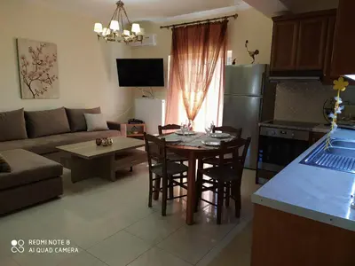 a kitchen and living room with a table and chairs at Joanna 's Loft in Kissamos