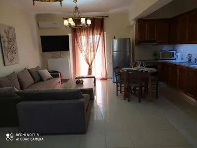 a living room and kitchen with a couch and a table at Joanna 's Loft in Kissamos