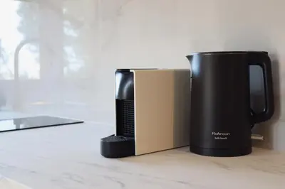 a coffee pot sitting on a counter next to a book at Villa Elea Apartments in Spiliá