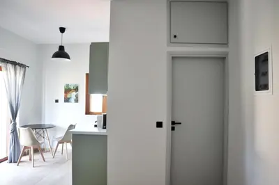 a room with a door and a kitchen with a table at Villa Elea Apartments in Spiliá