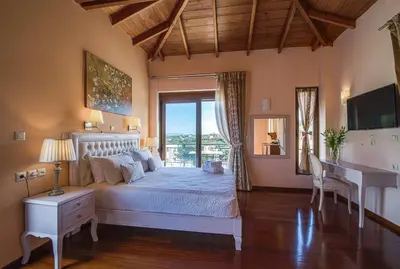 a bedroom with a bed and a desk and a window at Casa Leone Suites in Stalos