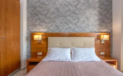 a bedroom with a large bed with two lamps at Christina Beach Hotel in Kissamos