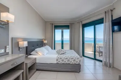 a bedroom with a bed and a view of the ocean at Christina Beach Hotel in Kissamos