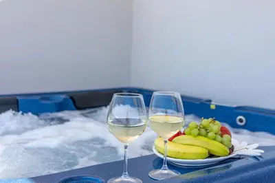 two glasses of white wine next to a plate of fruit at Christina Beach Hotel in Kissamos