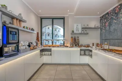 a kitchen with white counters and a large window at Christina Beach Hotel in Kissamos