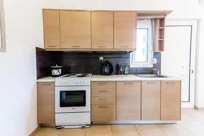 a kitchen with wooden cabinets and a stove at Pixelart Home in Kounoupidhianá