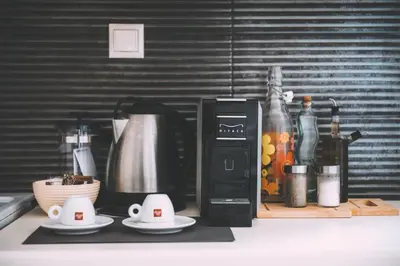a kitchen counter with a coffee maker and coffee cups at Pixelart Home in Kounoupidhianá