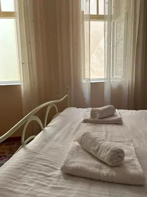 a bed with towels on it with a window at Sofias Home in Chania Town