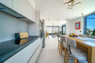 a kitchen and dining room with a counter and chairs at Naval villa-Panoramic villa with heated pool on the roof in Gerani Chanion