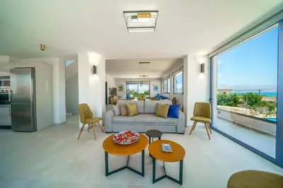 a living room with a couch and a table at Naval villa-Panoramic villa with heated pool on the roof in Gerani Chanion