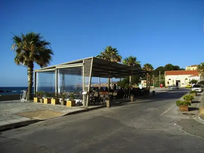 a building with a covering on a street with palm trees at Neoclassical Glamour in Chania Town