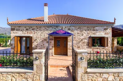 a small stone house with a blue roof at Villa Anerocurù by Chania city in Chania Town