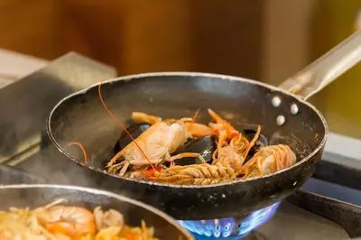 a wok filled with shrimp and other food at Casa Minaretto in Chania Town