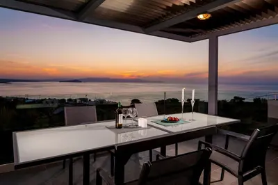 a dining table with a view of the ocean at Blue Sea Chania Villa in Chania Town