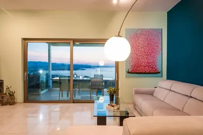 a living room with a couch and a view of the ocean at Blue Sea Chania Villa in Chania Town