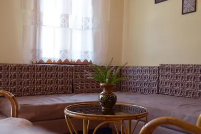 a living room with a couch and a vase on a table at Minaret's View ζήστε στην αύρα της παλιάς πόλης in Chania Town