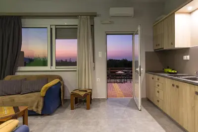 a kitchen and living room with a couch and a table at Nikis Apartments Kisamos in Drapaniás