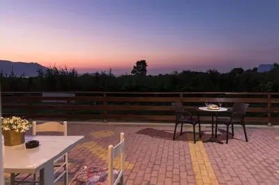 a patio with a table and chairs on a brick patio at Nikis Apartments Kisamos in Drapaniás