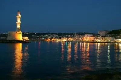 a lighthouse on the shore of a body of water at night at Kostaspant apartment in Gerani Chanion