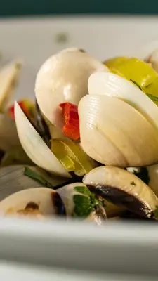 a pile ofcooked clams on a white plate at Maleme Mare in Maleme