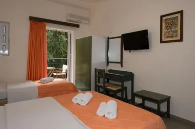a hotel room with two beds and a flat screen tv at Aretousa in Sougia